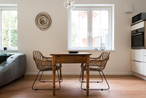 a kitchen with a wooden table and two chairs at Ferienwohnung am See "Flora" in Bad Zwischenahn