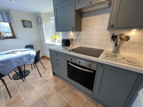 a kitchen with a sink and a stove top oven at Pretty Cottage In Charming Peaceful Village - Easy Commute to Cambridge - Cambridge Homehost in Cambridge