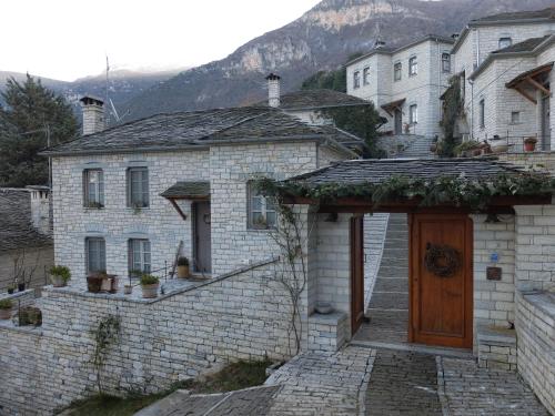 a brick house with a wooden door in a village at Artsistas Houses in Aristi