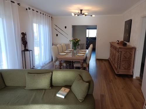 un salon avec un canapé vert et une table dans l'établissement Villa Savana - Élégance & Confort près des plages, à Langueux