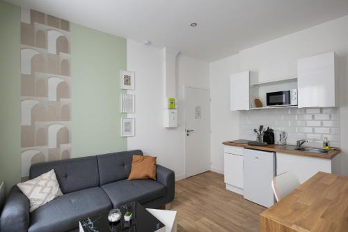 un salon avec un canapé et une cuisine dans l'établissement Le Triomphant, à Brest