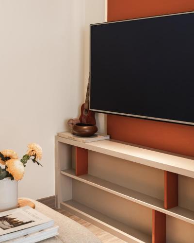 a tv on a shelf in a living room at 2BR Cozy City View CBD Sudirman Park Apartment, Luxury & Chic Design in Jakarta
