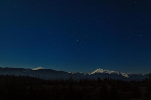 a night view of a mountain range with snow capped mountains at Blyzhche Neba in Yablunytsya