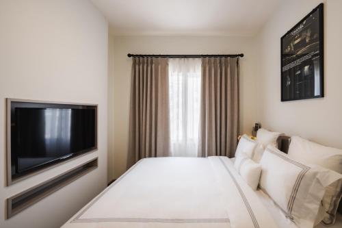 a hotel room with a bed and a flat screen tv at 2BR Cozy City View CBD Sudirman Park Apartment, Luxury & Chic Design in Jakarta