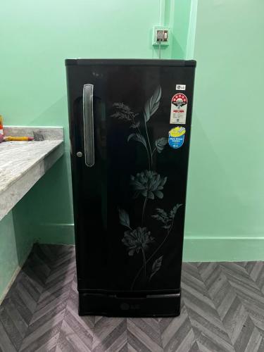 a black refrigerator with a painting of flowers on it at The Painted Horizon in Namchi