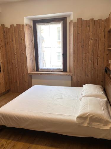 a bedroom with a large bed with a window at Melissa in Belluno