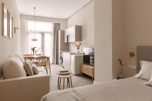 a bedroom with a bed and a kitchen with a table at MH Apartments Central Valencia in Valencia