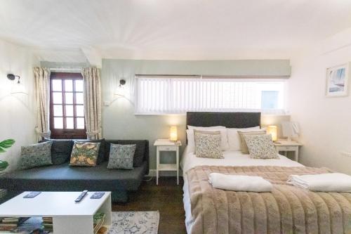 a living room with two beds and a couch at Poole Park House in Poole