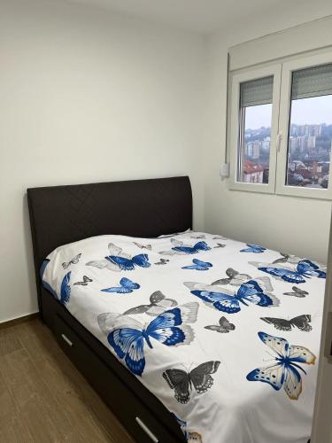 a bedroom with a bed with blue butterflies on it at Mimura stan in Belgrade