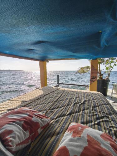 a bed on the back of a boat with the ocean at Casa Acuarimantima in Tintipan Island