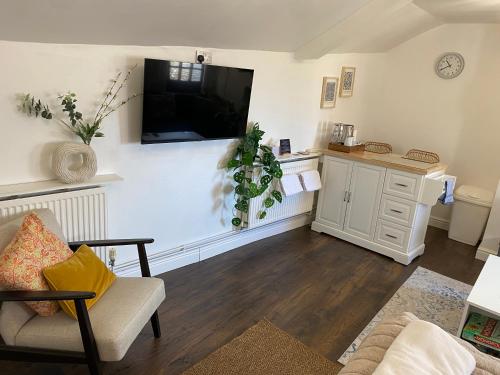 a living room with a flat screen tv on the wall at Poole Park House in Poole