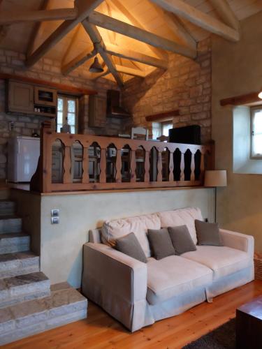 a living room with a white couch and stairs at Artsistas Houses in Aristi