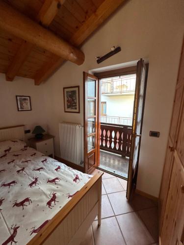a bedroom with a bed and a balcony at Casa tra le nuvole in Dazio