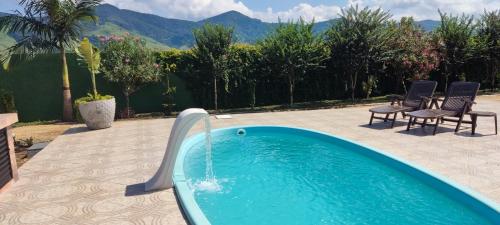 a pool with a water slide in a backyard at Chalé de alto padrão em condomínio in Santa Rita do Sapucaí
