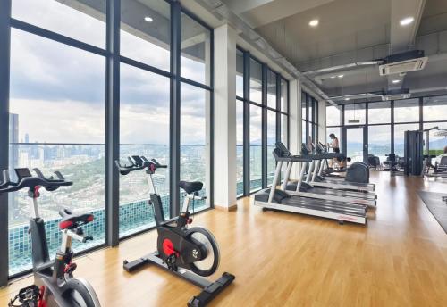 un gimnasio con cintas de correr y bicicletas estáticas frente a las ventanas en Ekocheras Creamy Stay, en Kuala Lumpur