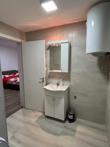 a bathroom with a sink and a mirror and a bed at Mimura stan 2 in Belgrade