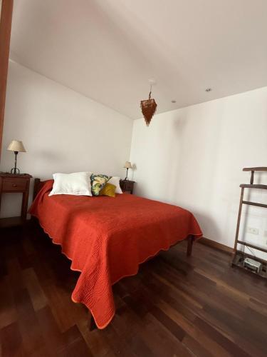 a bedroom with a bed with a red blanket at Departamento San Bernardo - Céntrico Salta in Salta