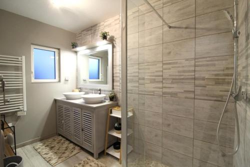 a bathroom with a shower and a sink and a mirror at Gite, Maison Chaleureuse in Saint-Léonard