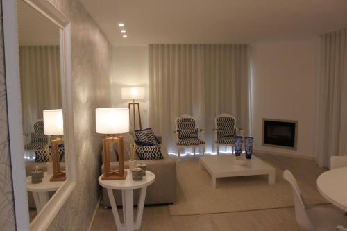 a living room with chairs and a table and a mirror at Apartamento Morning Cascade in Carvoeiro