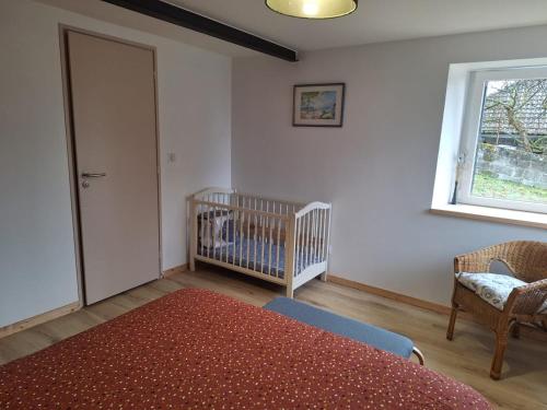 a bedroom with a crib and a baby crib at Gite authentique au coeur de Blavozy avec piscine privée, jacuzzi et terrain de pétanque in Blavozy