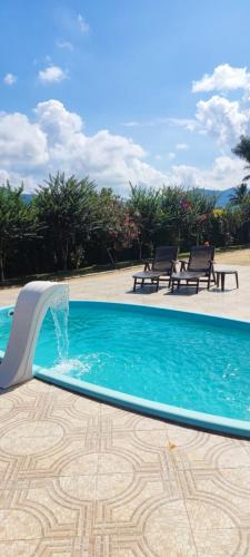 a swimming pool with a water fountain at Chalé de alto padrão em condomínio in Santa Rita do Sapucaí