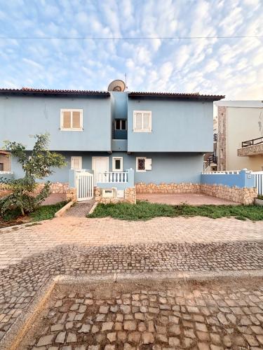 a blue house with a stone driveway in front of it at Blue Oceano in Santa Maria