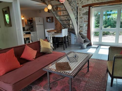 un salon avec un canapé rouge et une table dans l'établissement Gîte atypique Nature La Cabane, à Vieille-Brioude