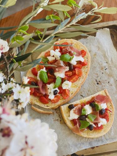 two pizzas with toppings on a table with flowers at Peterc Vineyard Estate in Kojsko