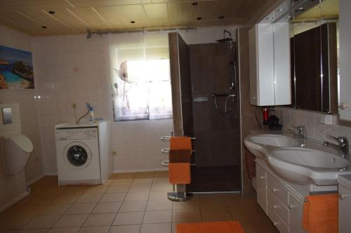 a bathroom with a sink and a washing machine at Ferienwohnung Kohler in Königsfeld