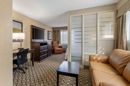 a hotel room with a couch and a desk at Best Western Plus InnTowner Madison in Madison