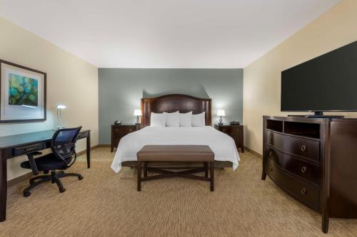 a bedroom with a bed and a desk and a television at Best Western Plus InnTowner Madison in Madison