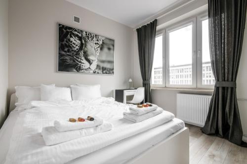 Un dormitorio con una cama blanca con toallas. en Apartament Centrum Żurawia, en Varsovia