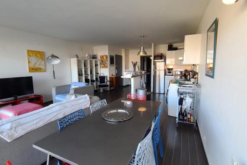 un salon avec une table et une cuisine dans l'établissement Beautiful T3 with balcony near the beach, à Arcachon