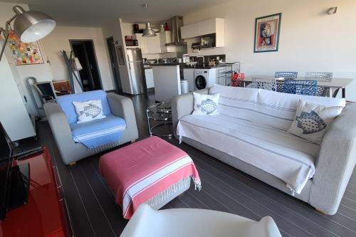 un salon avec un canapé et une chaise dans l'établissement Beautiful T3 with balcony near the beach, à Arcachon