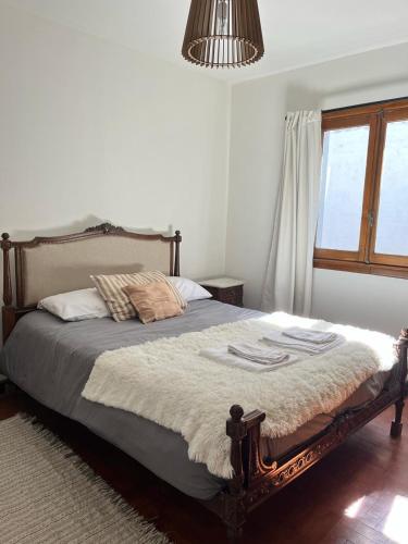 a bedroom with a bed in a room with a window at Peonía Tempo in Esquel