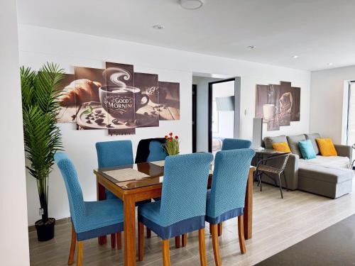a dining room with a table and blue chairs at Mantu Apartment in Cusco