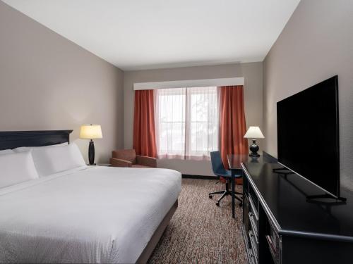 a hotel room with a bed and a flat screen tv at Garner Hotel Gillette South by IHG in Gillette