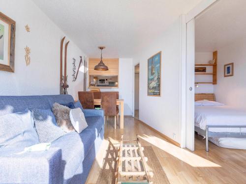un salon avec un canapé bleu et une chambre dans l'établissement Charmant 2 Pièces, Balcon Sud, TV, WiFi, Casier à skis - FR-1-314-217, à Morzine