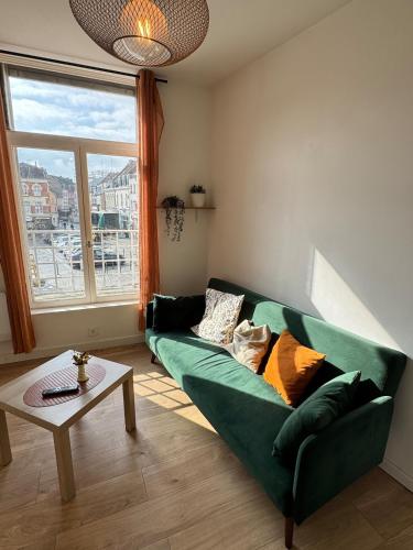 un salon avec un canapé vert et une table dans l'établissement Magnifique Appartement Au Cœur du Centre-Ville, à Tourcoing