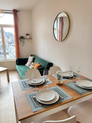 une salle à manger avec une table avec des assiettes et des verres à vin dans l'établissement Magnifique Appartement Au Cœur du Centre-Ville, à Tourcoing