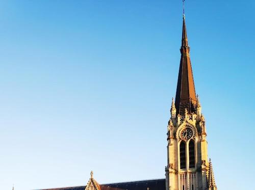 a church steeple with a clock on it at Magnifique Appartement Au Cœur du Centre-Ville in Tourcoing