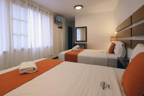 a hotel room with two beds and a window at La Posada de Mindo in Mindo