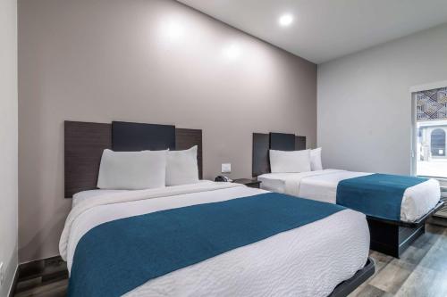 a bedroom with two beds and a window at Studio 6 Suites Brenham, TX in Brenham