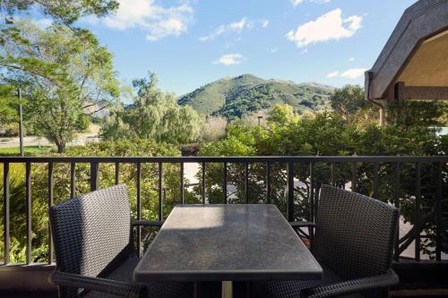 a table and chairs on a balcony with a mountain at La Cuesta Inn, BW Signature Collection in San Luis Obispo