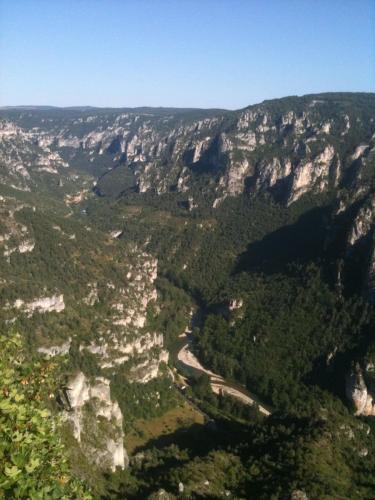 une vue aérienne sur une vallée montagneuse avec une route dans l'établissement Maison en pierre Gorges du Tarn, à Saint-Georges-de-Lévéjac