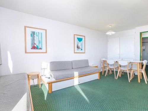 Cette chambre comprend un canapé, une table et des chaises. dans l'établissement Appartement 7 personnes avec balcon, WIFI et casier à skis - FR-1-314-244, à Morzine