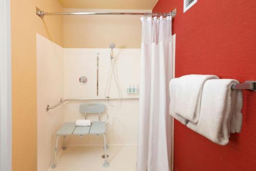 a bathroom with a shower with a chair in it at Courtyard Costa Mesa South Coast Metro in Santa Ana