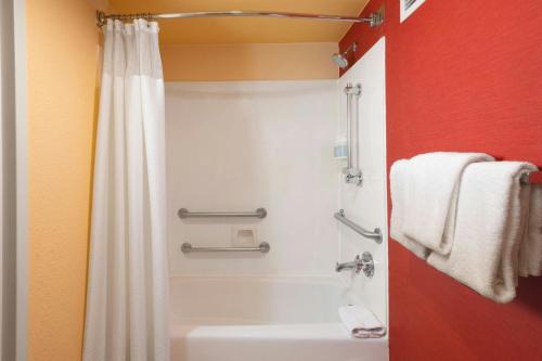 a bathroom with a shower and a white tub at Courtyard Costa Mesa South Coast Metro in Santa Ana