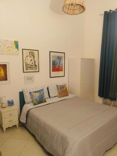 a bedroom with a large bed and some pictures on the wall at B&B IL POETA in Palermo