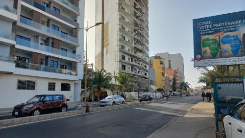 a street with cars parked on the side of the road at Furnished studio in Mermoz in Dakar